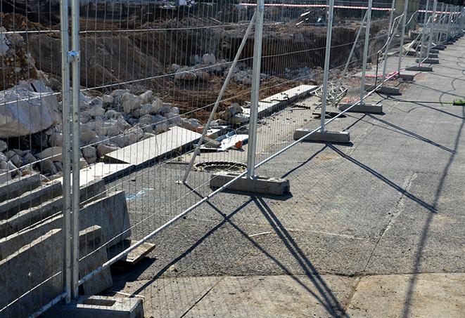 temporary fence panels protecting a newly paved area from foot traffic